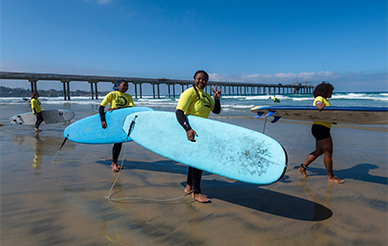 students with surfboards at the beach